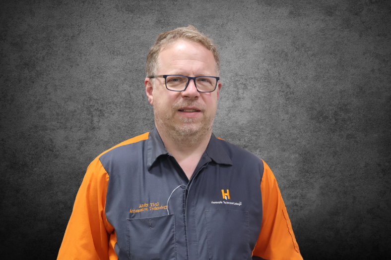 A headshot photo of Andrew Thul on a gray background.