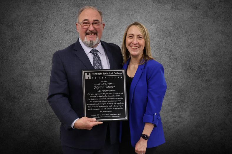 Former Foundation Board Chair Myron Moser poses, plaque in hand, with Advancement Vice President and Foundation Executive Director Alison Forbes.